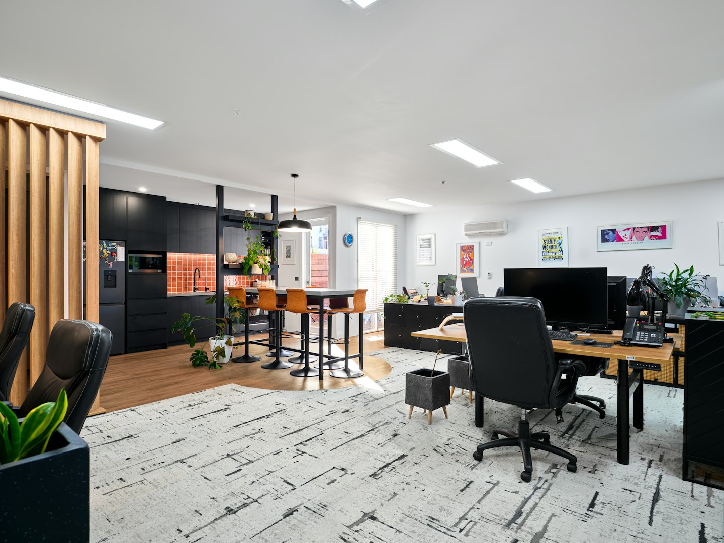 Moderne open kantoorruimte met keuken en werkplekken.