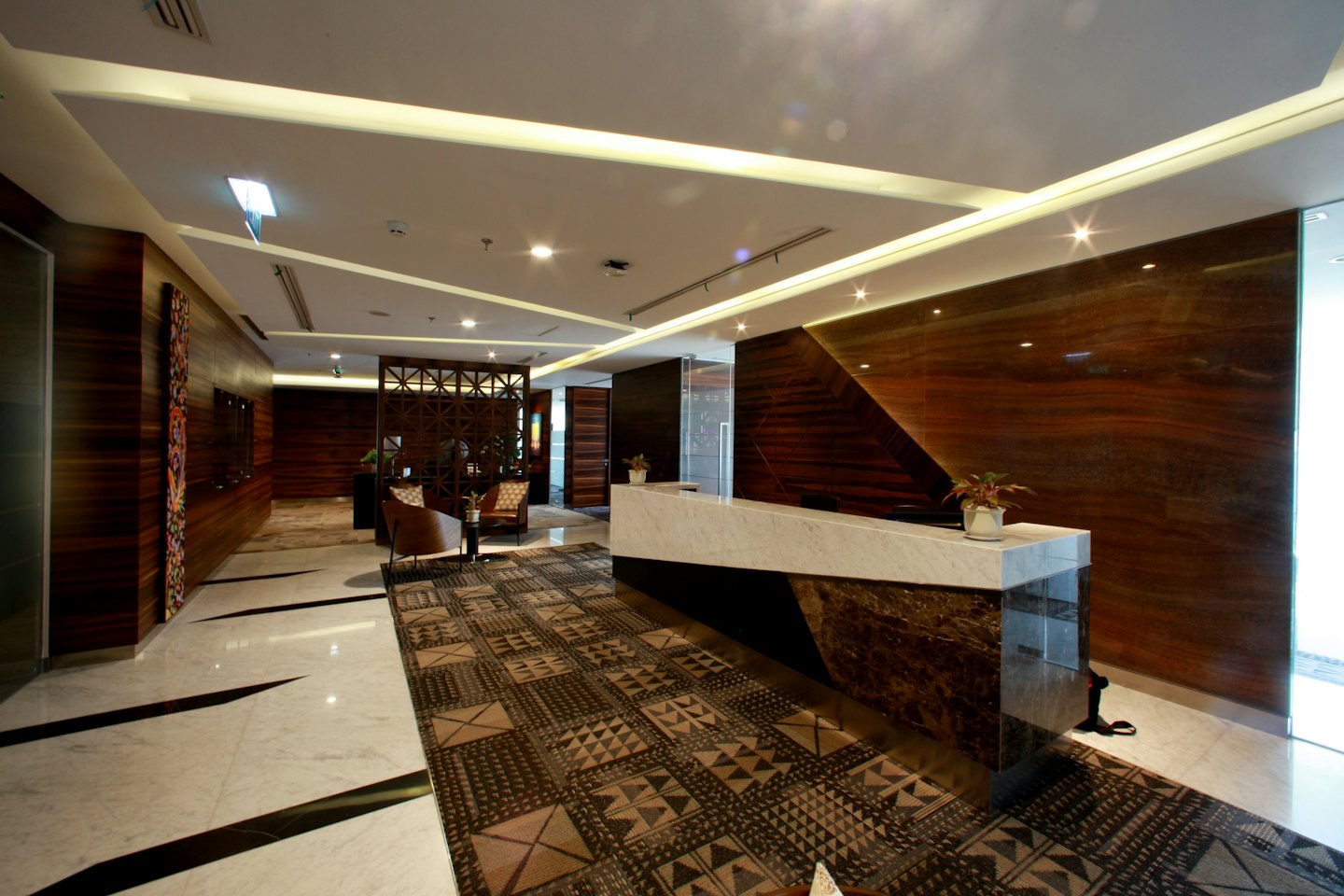 Marmeren receptiebalie in een moderne lobby van een bedrijfsgebouw.